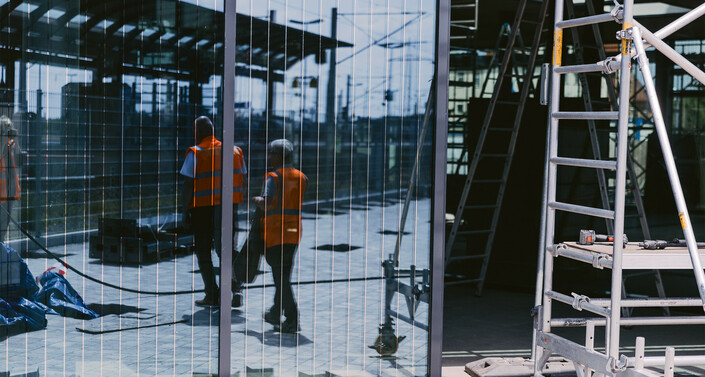 Bild einer Glasscheibe im neuen Bahnhof. In der Scheibe sind Alufäden zu sehen.