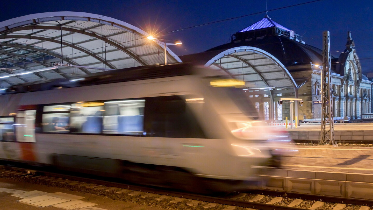 Ein Nahverkehrszug verlässt den Hauptbahnhof Halle (Saale) bei Nacht