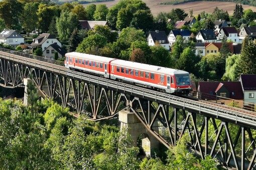 ein roteer Triebwagen der Baureihe 628 fährt über eine Eisenbahnbrücke