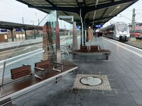 Neugestalteter Bahnsteig in Dessau Hauptbahnhof mit Sitzänken aus Holz und verzierten Glaswänden.