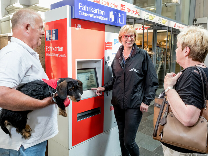 Senioren vor einem Fahrkartenautomat mit Frau Havemann